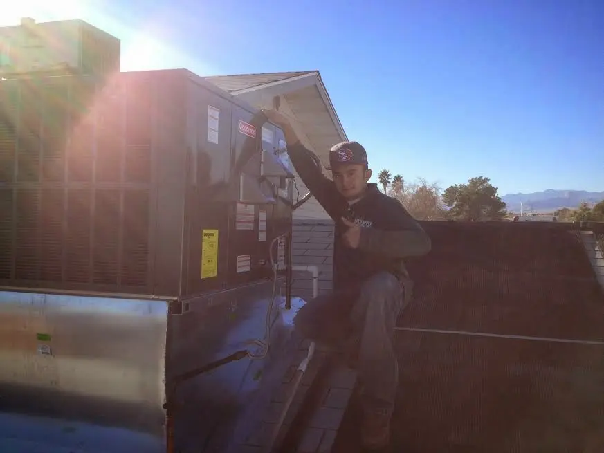 HVAC technician performing AC Tune-Up on a rooftop unit in Meridian